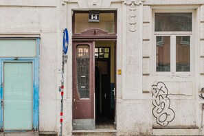 Distinct entrance with a brown door and sign featuring the number 14, flanked by a blue door and window.
