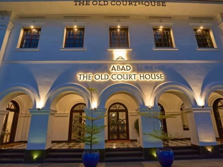 The facade of The Old Court House, featuring a classical architectural style with arched windows and a prominent entrance.