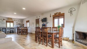 Una sala de estar amplia con chimenea, un comedor con muebles de madera y una cocina con electrodomésticos modernos.