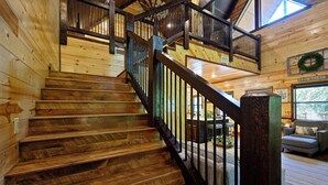 Un escalier en bois avec une rampe métallique menant à un niveau supérieur.