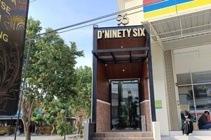 Entrada do D'Nevery Six, com design moderno, porta de vidro e fachada de tijolos.