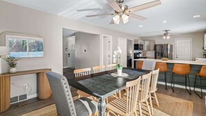 A modern kitchen with a central island, wooden chairs, and a dining table. - Hot Tub - Game Room - Sleeps 10 - Vermilion (Vermilion)