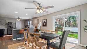 A modern kitchen with a dining area, a ceiling fan, and a large sliding glass door to the outdoors. - Hot Tub - Game Room - Sleeps 10 - Vermilion (Vermilion)