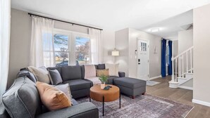 A modern living room with a grey sectional sofa, a round coffee table, and a patterned rug. - Hot Tub - Game Room - Sleeps 10 - Vermilion (Vermilion)