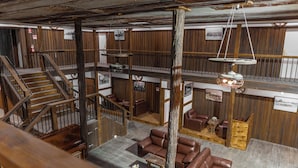 A multi-level wooden interior with a staircase, leather seating, and hanging light fixtures. - Mount Mee Country Lodge (Mount Mee)
