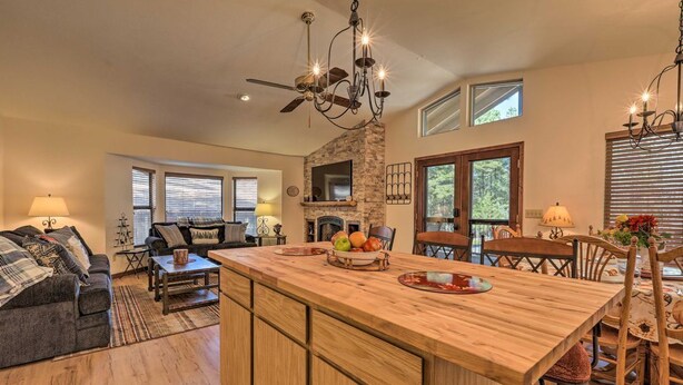A spacious living area with a large wooden island, a fireplace, and a ceiling fan. - Bobcat Bungalow - Quaint, Quiet & Cozy Retreat in Munds Park - Yes, there's A/C! (Munds Park)