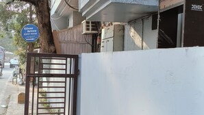 A gated entrance with a blue sign indicating a guest house. - Silver Arrow Guest House  (New Delhi)
