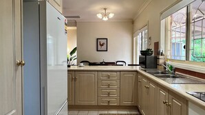 Une cuisine équipée d’un réfrigérateur encastré, d’une fenêtre avec vue, d’un ventilateur de plafond et d’un évier.