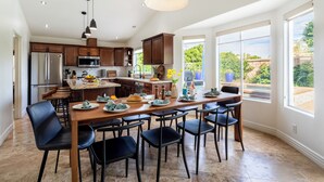A modern kitchen with dark wooden cabinets, stainless steel appliances, and a large island with seating.