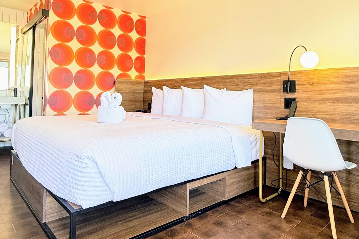 Una habitación de hotel moderna con una cama, un escritorio y una silla.