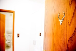 A wooden door with a deer head cutout and the number 121. - A comfortable and versatile room—perfect for relaxation, work, and socializing (Winterberg)