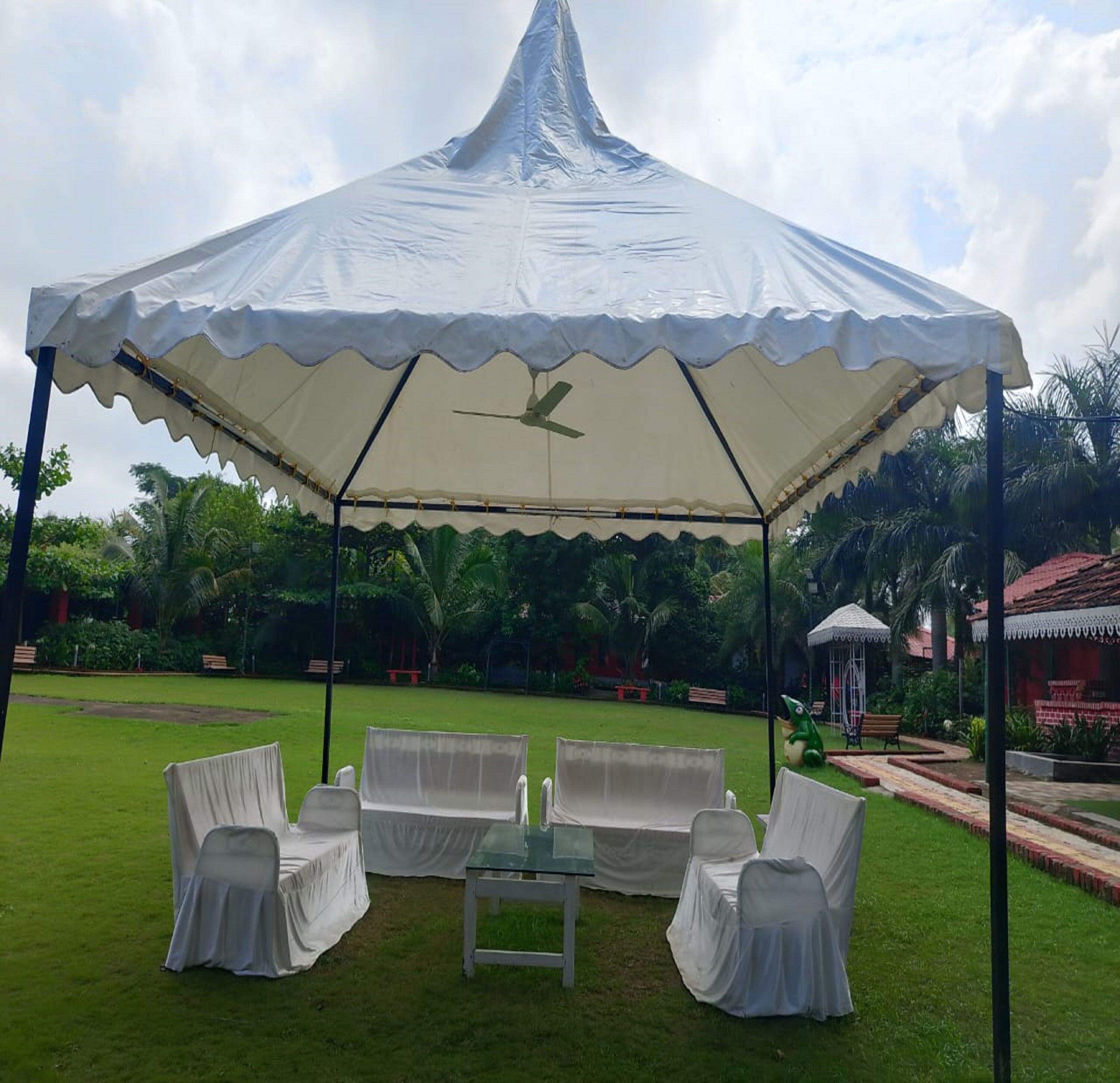 A tent with a table and chairs set up on a grassy area.