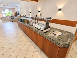 A buffet setup with a marble countertop, a variety of dishes, and a decorative deer figurine. - Comfortable and versatile room -perfect for relaxation, work and exchange (Winterberg)