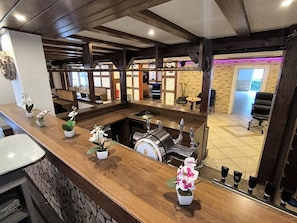 A bar area with a counter, potted orchids, and a beer tap.