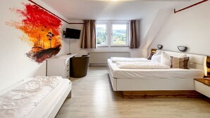 A bedroom with two beds, a TV, a radiator, and a window with a view. - Comfortable and versatile room -perfect for relaxation, work and exchange (Winterberg)