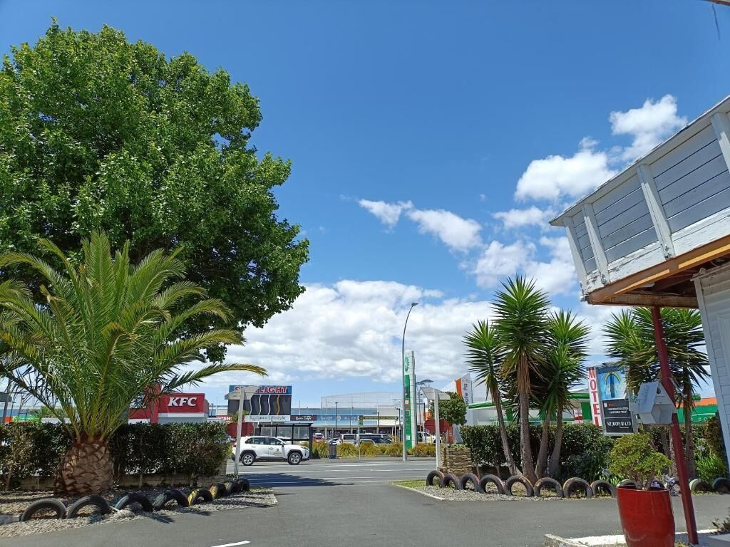 A KFC restaurant, a motel, and a gas station with a clear sky.