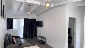 Ett modernt vardagsrum med en soffa, ett soffbord och en tv-apparat med platt skärm.