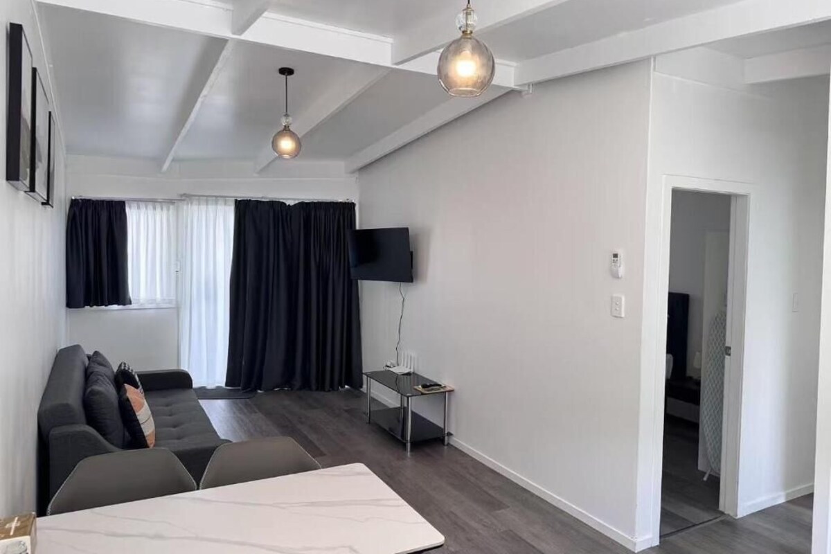 Ett modernt vardagsrum med en soffa, ett soffbord och en tv-apparat med platt skärm.
