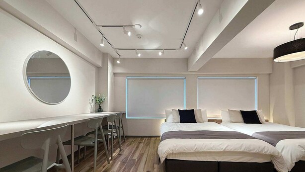 A modern bedroom with a desk, two beds, and a large mirror. - Fully Equipped Studio Getaway (Hiroshima)