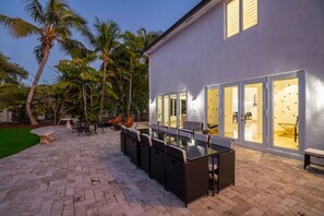 Relax in style on this outdoor patio with a glass-top table and comfortable wicker seating.