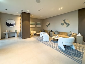 A modern living room with a sofa, armchairs, a coffee table, and a side table.