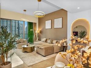 A modern living room with a sofa, coffee table, and a large window offering a city view.