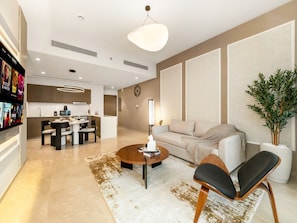 A modern living room with a sofa, a coffee table, and a dining area with chairs.