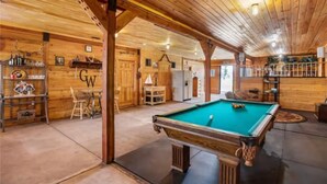 A wooden interior with a pool table, bar area, and seating. - Rustic Barn on 51 Acres (Cripple Creek)