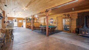 A wooden interior with a pool table, seating area, and a fireplace. - Rustic Barn on 51 Acres (Cripple Creek)