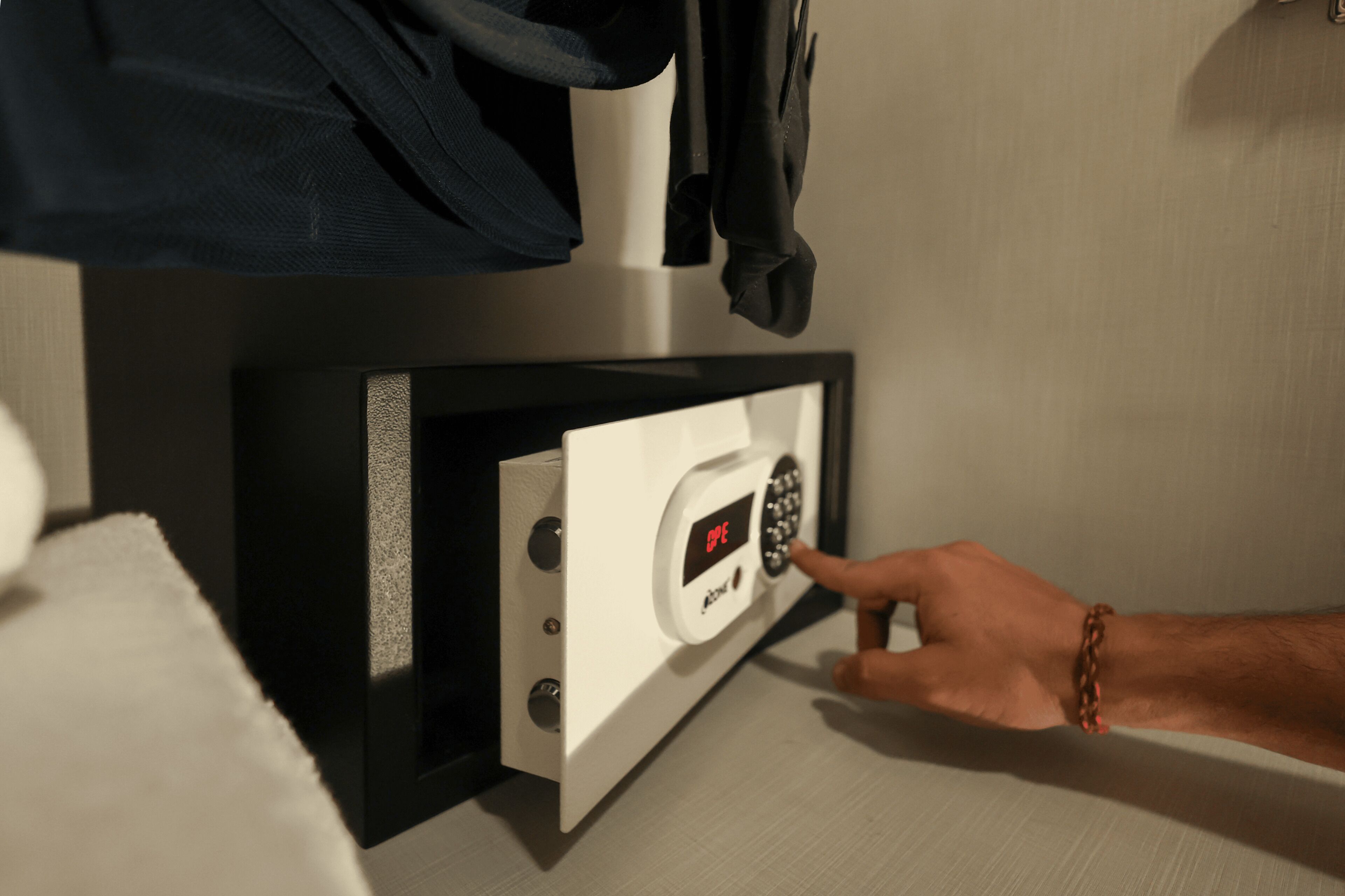 A hand pressing a button on a control panel with a digital display.