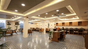 A spacious hotel lobby with a tiled floor, multiple seating areas, and a reception desk. - Arjun - A boutique hotel (Haridwar)