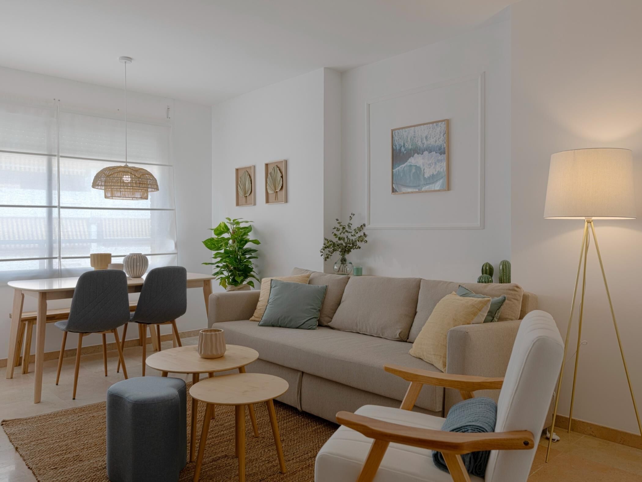 Ein modernes Wohnzimmer mit einer Couch, Sesseln, einem Esstisch und einer Stehlampe.