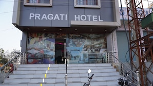 Fachada do Hotel Pragati com uma escadaria que leva à entrada.