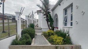 Un edificio bianco con un vialetto lastricato che conduce a una porta.