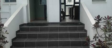 A staircase leading to a door with a decorative glass panel.