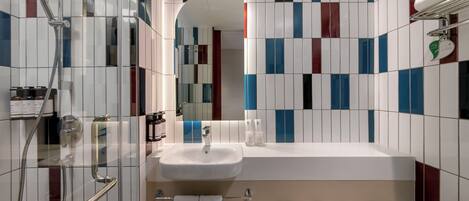 A modern bathroom with a shower, sink, and mirror.