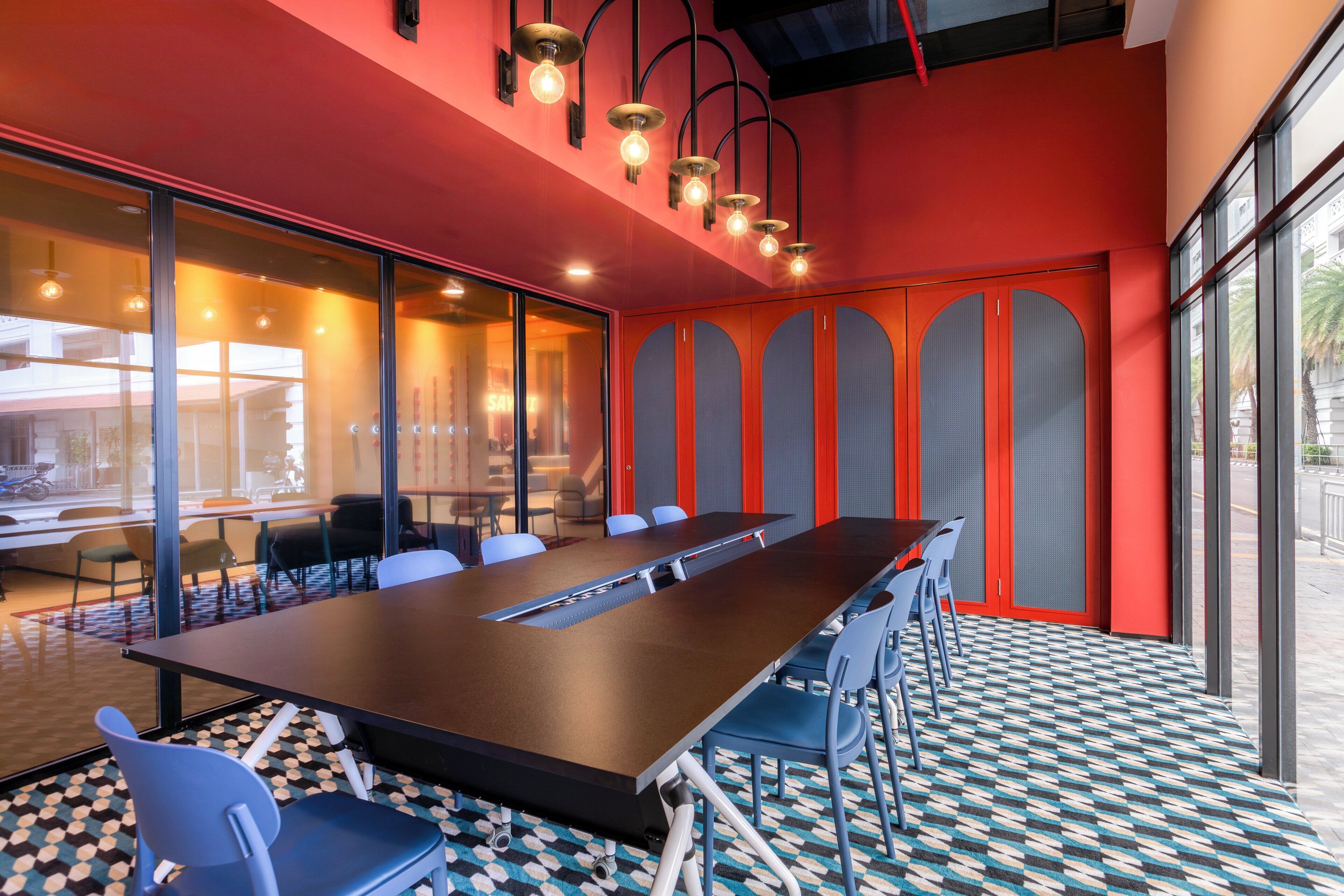 A conference room with a long table, chairs, and a patterned floor.