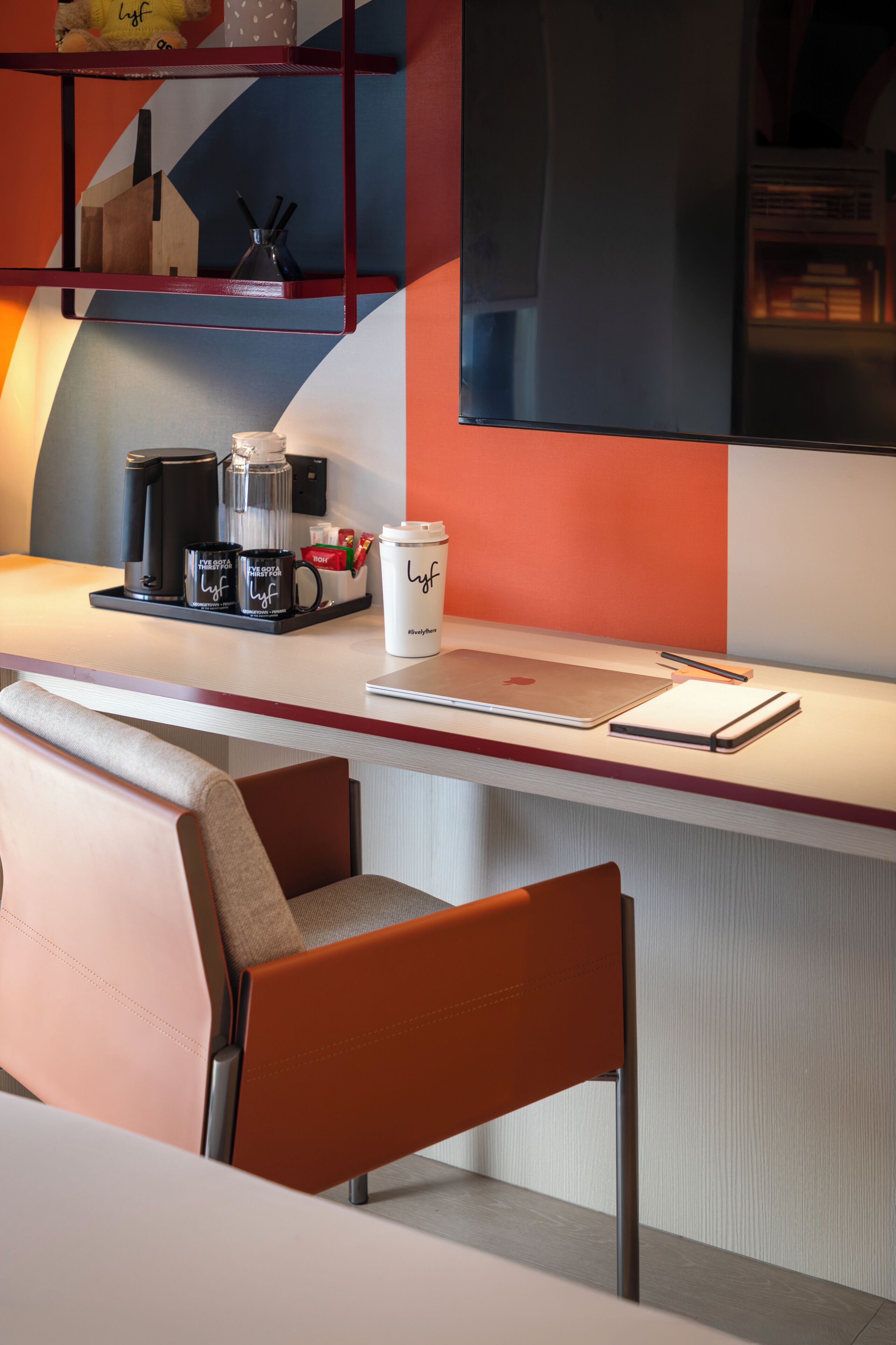 A modern bar area with seating, a coffee station, and a laptop on the counter.