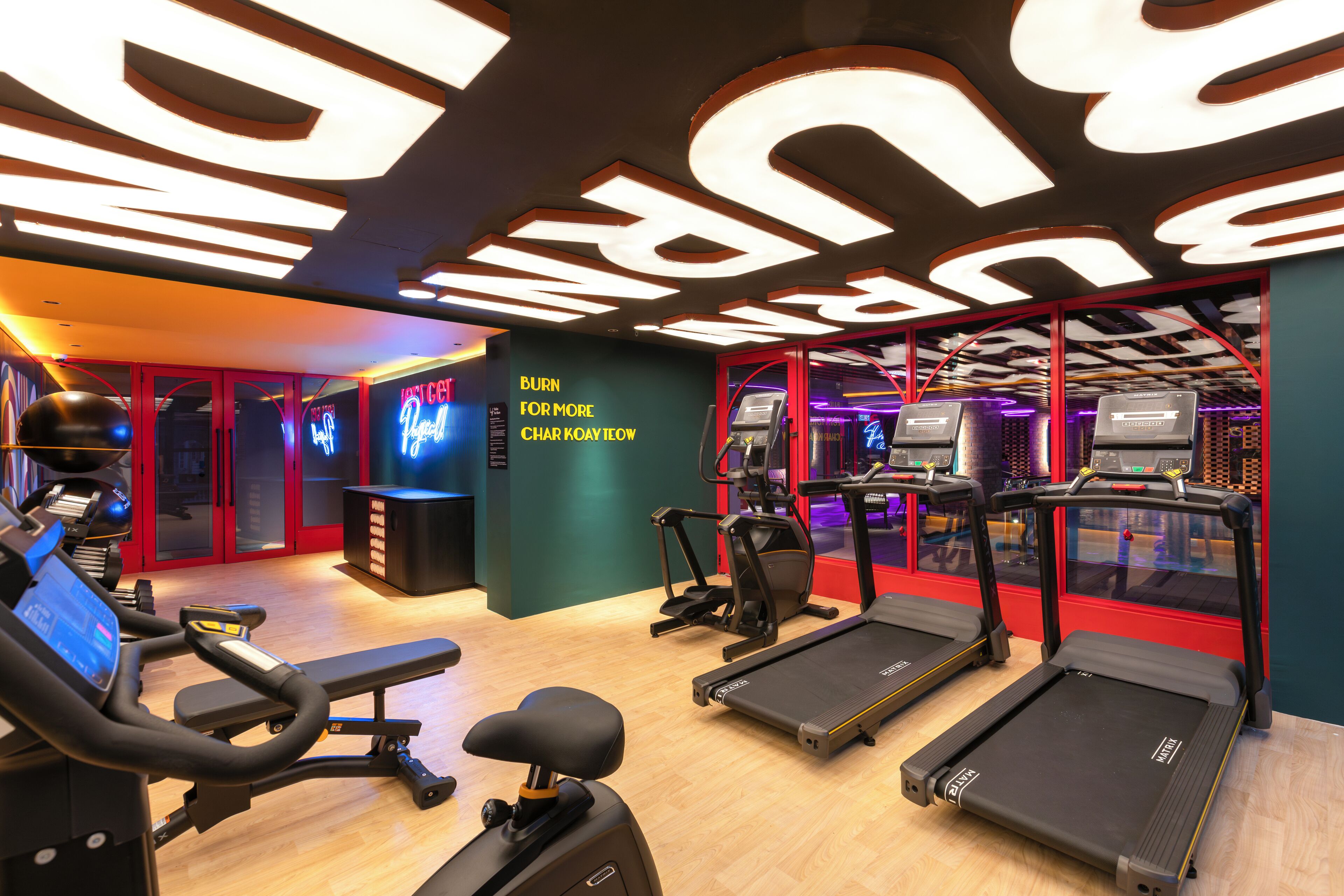 Une salle de sport équipée de tapis de course, d’un vélo d’appartement et d’un appareil d’aviron.