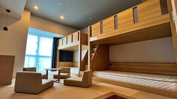 A modern room with bunk beds, a sofa, a small table, and a window with curtains.