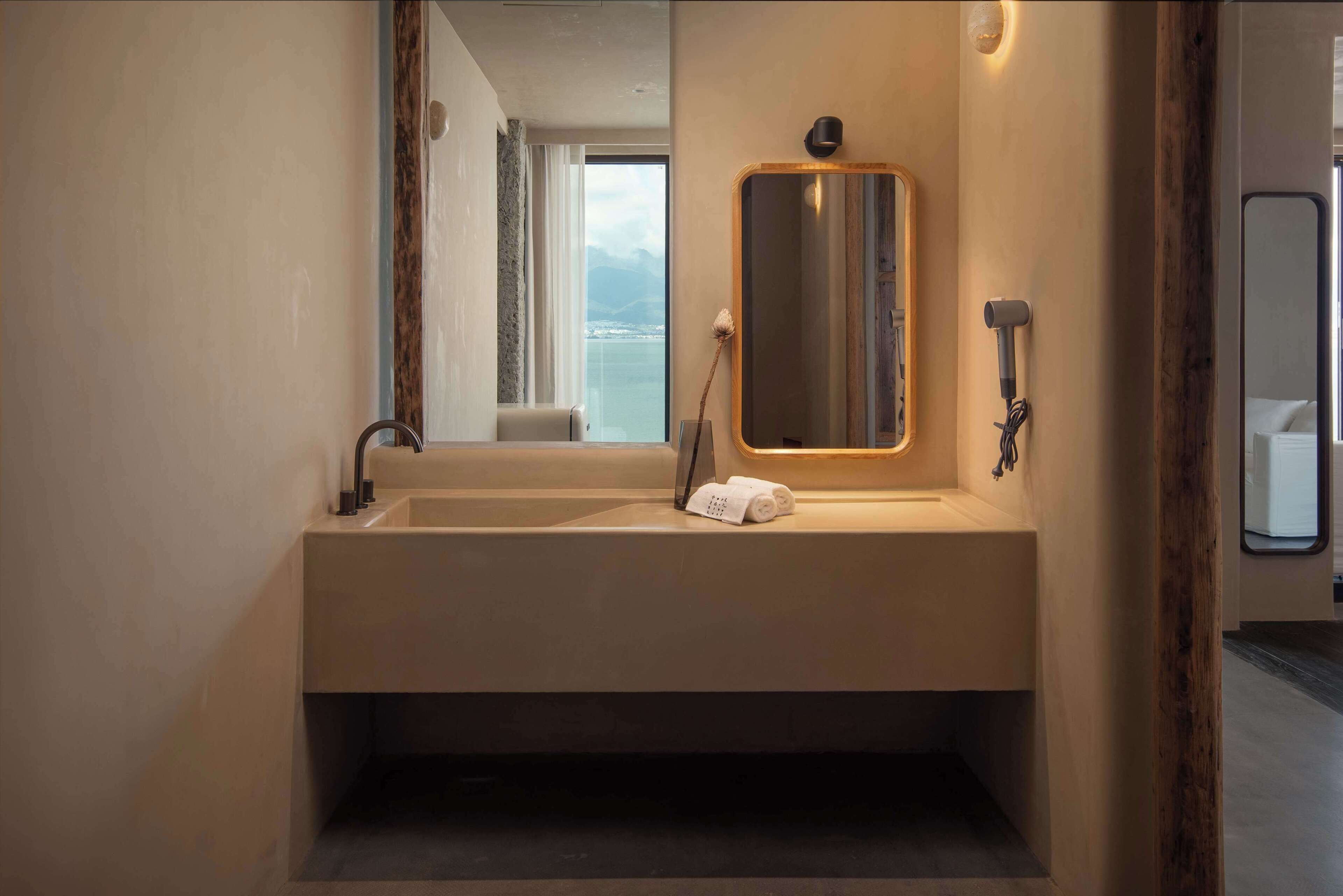 Une salle de bain moderne avec un grand miroir, une serviette et un sèche-cheveux.