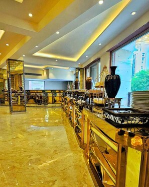 A spacious hotel lobby with a marble floor, a central bar area with a large black vase, and a view of a building through the window. - Hotel Castle Grand (New Delhi)