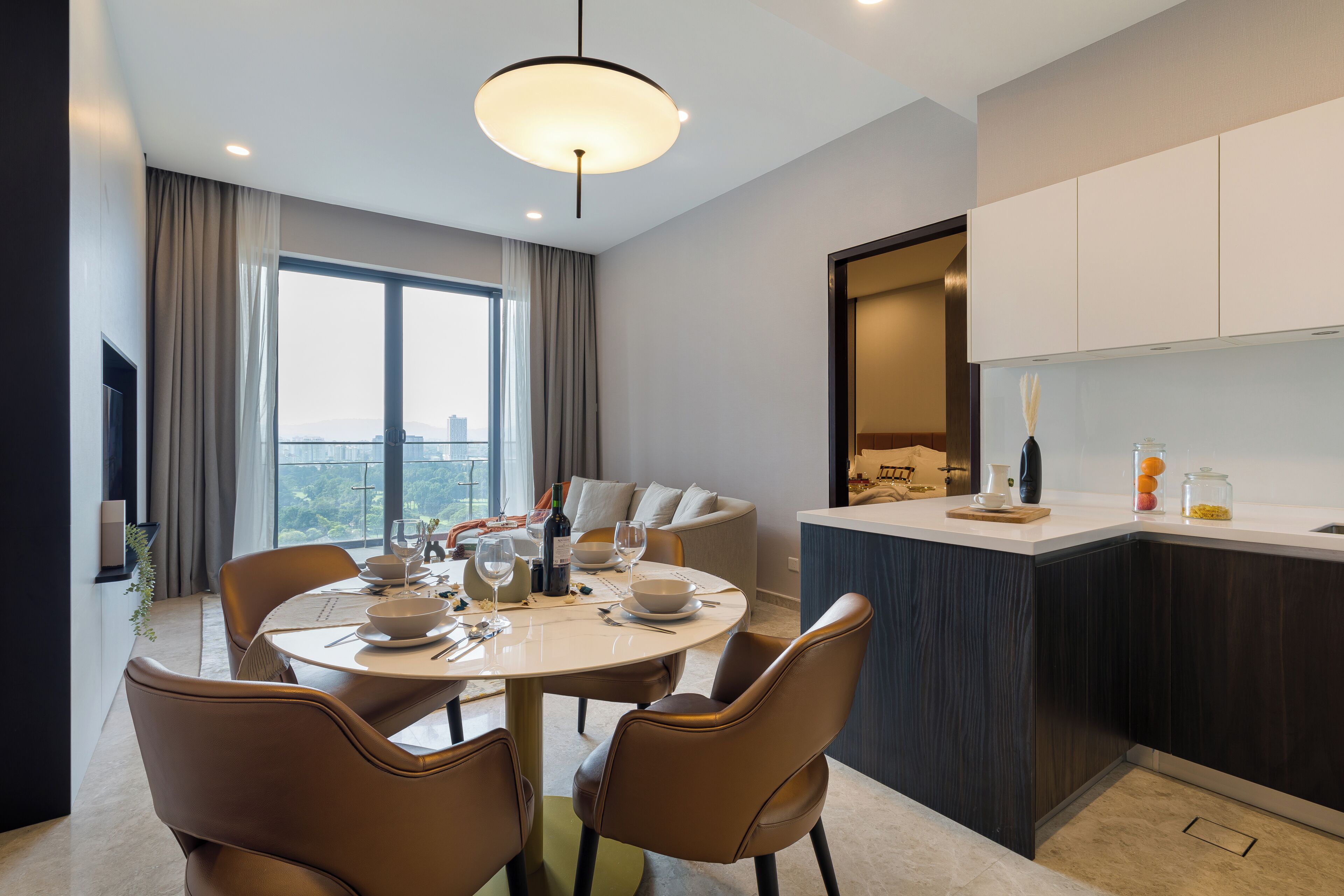 Un espace repas moderne avec une table ronde, des chaises et une vue sur la ville.