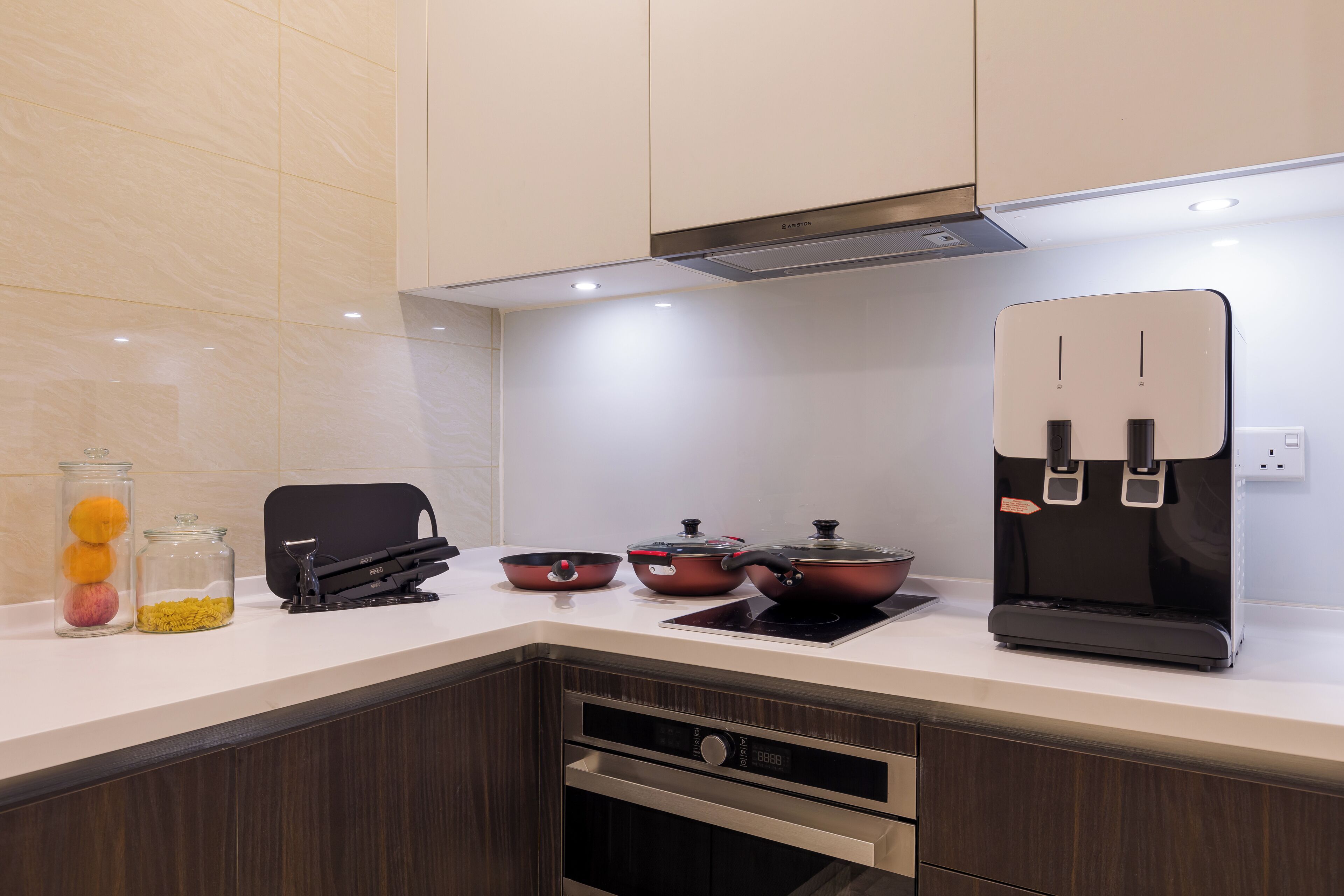 A modern kitchen with a white countertop, stainless steel appliances, and a built-in oven.