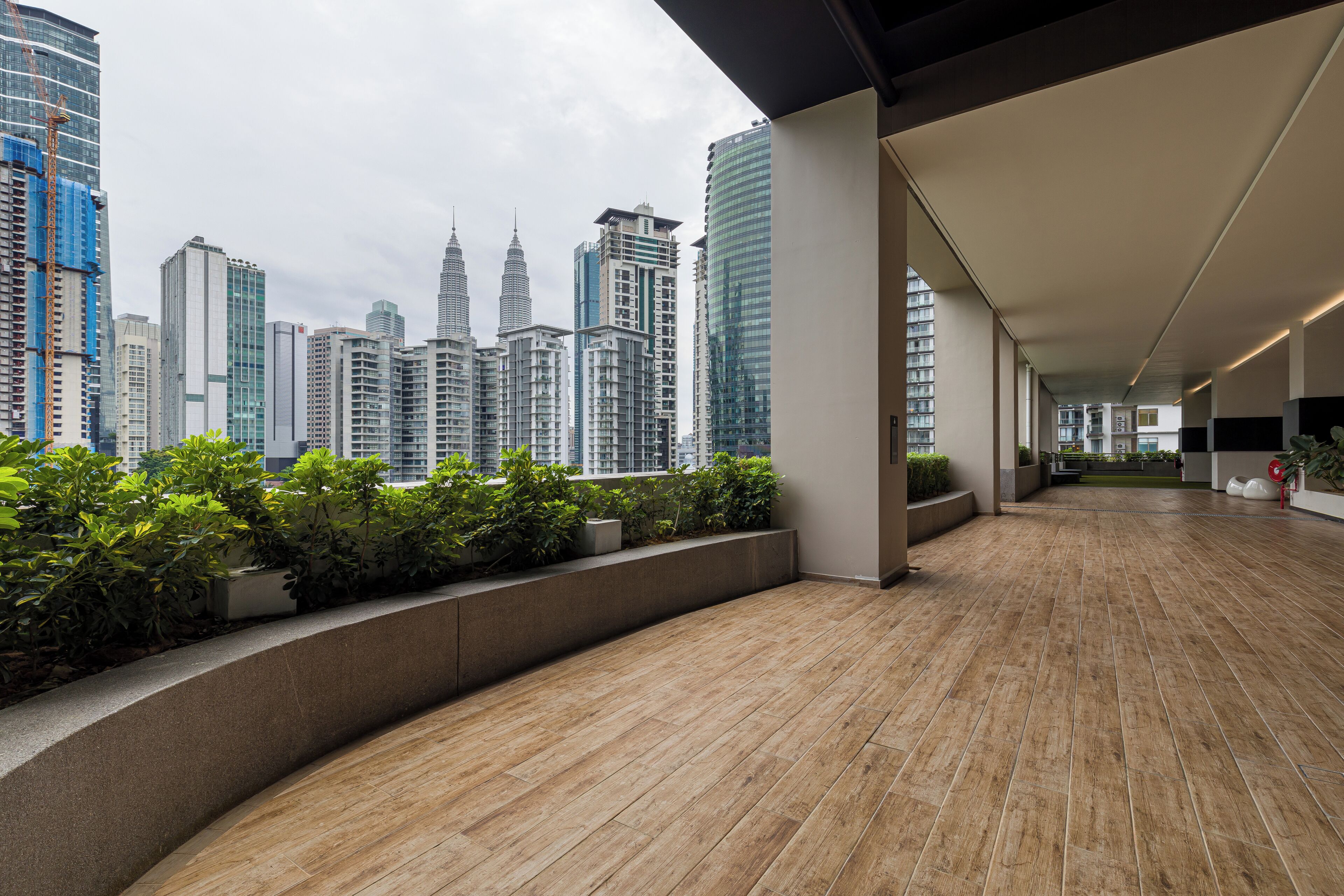 Spazio interno moderno con vista sullo skyline cittadino, caratterizzato da grattacieli e un’area verde con piante.
