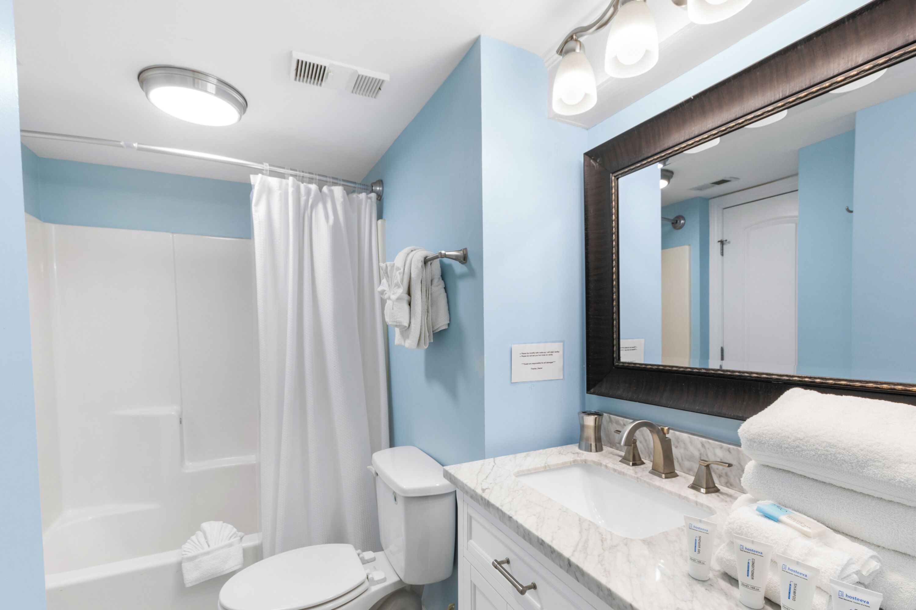 Une salle de bain moderne équipée d’une douche, de toilettes, d’un lavabo et d’un grand miroir.