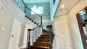 A staircase with ornate black railings and wooden steps leading to an upper floor. - Villa Sapporo Seiga (Sapporo)