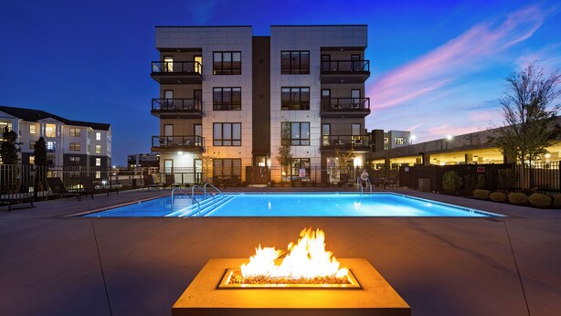 Un edificio moderno con piscina y una chimenea decorativa al frente.