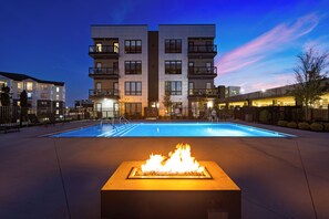 Un edificio moderno con piscina y una chimenea decorativa al frente.