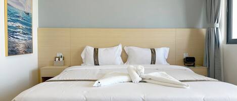 A hotel room with a large bed, a headboard, a nightstand, a wall-mounted air conditioner, and a window with curtains.